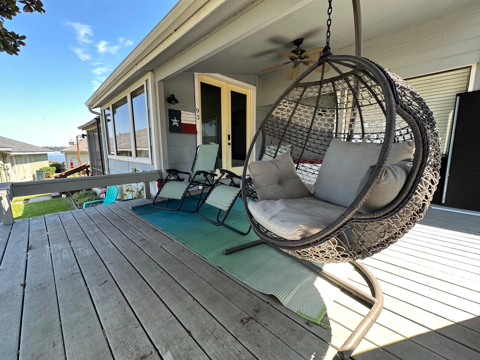 Covered deck at Casa Sunset Lake Conroe with hanging chair and lounge seating